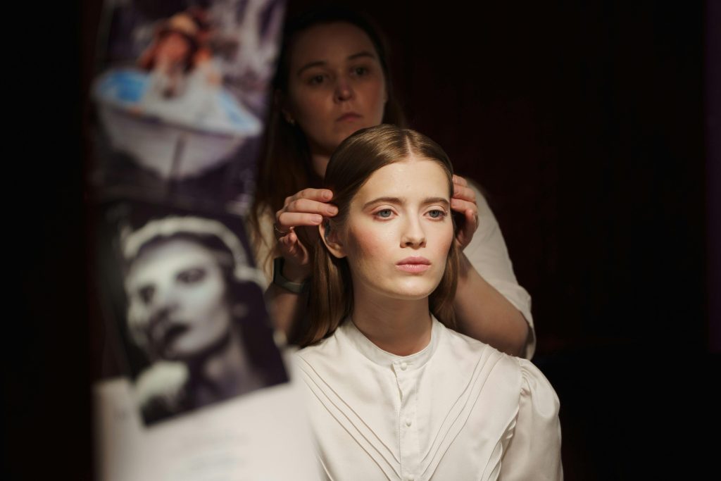 Hair, Wigs, Makeup & Prosthetics Technician apprentice applying stage makeup